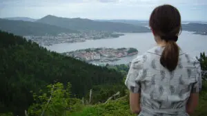 A woman sits looking out over the Norwegian port city of Bergen